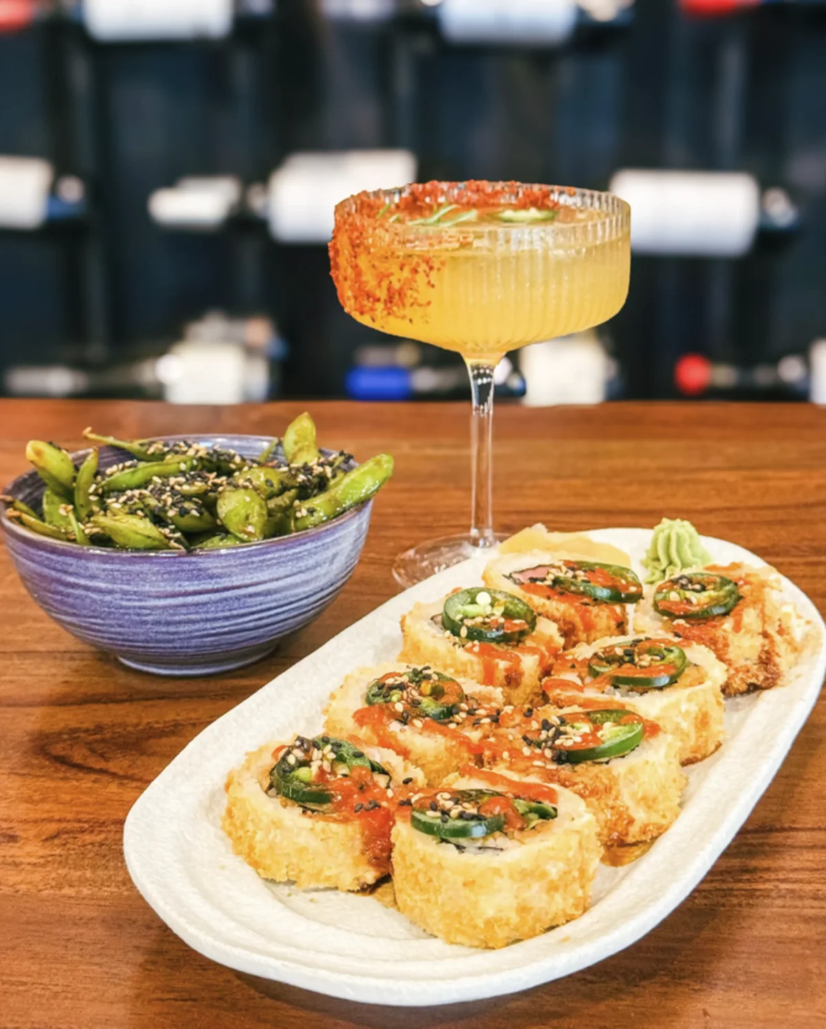A crispy sushi roll platter with a spice-rimmed cocktail and sesame edamame at Momento Wine & Sushi Bar