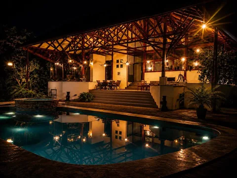 Casa Cascada's covered pavilion and pool lit up at night with string lights