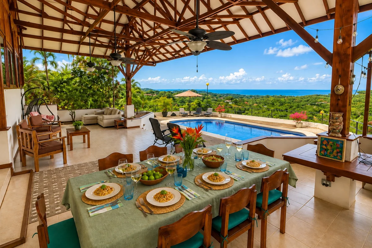 A covered outdoor dining table set for lunch beside a pool with a sweeping Pacific Ocean view near Ojochal