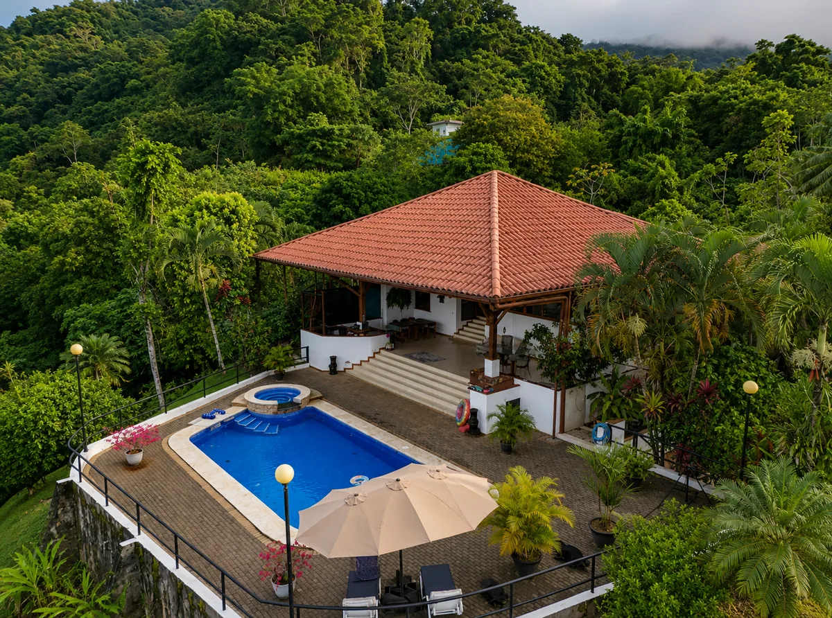 Aerial view of Casa Cascada's terracotta tile roof, pool, and surrounding jungle above the Pacific coastline