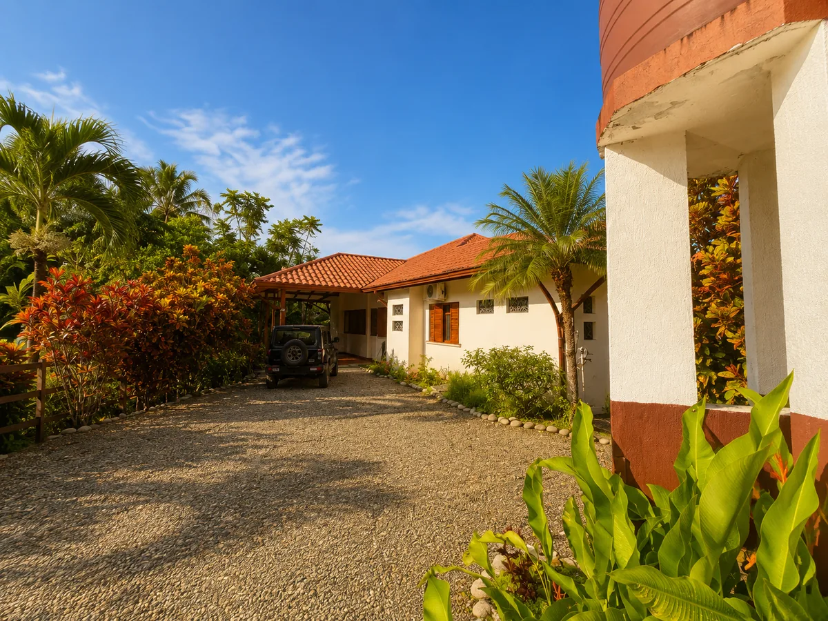 The gravel driveway arriving at Casa Cascada, lined with tropical landscaping